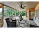 Covered patio with comfortable seating, ceiling fan, brick accents, and views of the beautiful backyard at 2118 Town Manor Ct, Dacula, GA 30019