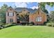 Elegant brick home featuring manicured lawn, mature trees, and a welcoming entrance at 2118 Town Manor Ct, Dacula, GA 30019