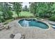 Aerial view of backyard pool and spa surrounded by landscaped grounds, stone pavers and lush trees at 2118 Town Manor Ct, Dacula, GA 30019