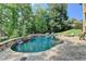 Inviting backyard pool with stone accents, lush greenery and a brick patio for relaxation at 2118 Town Manor Ct, Dacula, GA 30019