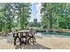 Beautiful backyard pool area with stone accents, lounge chairs, and a table with chairs for outdoor relaxation at 2118 Town Manor Ct, Dacula, GA 30019