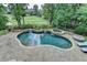 Inviting backyard oasis features a custom pool, spa, and a lush green golf course view at 2118 Town Manor Ct, Dacula, GA 30019