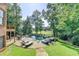 Luxury backyard oasis with a stunning pool, stone patio, lounge chairs, and lush landscaping at 2118 Town Manor Ct, Dacula, GA 30019