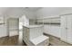 Spacious walk-in closet with custom shelving, storage island, and hardwood floors, offering ample space for organization at 2118 Town Manor Ct, Dacula, GA 30019