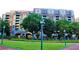 Landscaped exterior with a multi-story brick building with a gated entrance viewed from a green space at 250 Park Avenue West # 802, Atlanta, GA 30313