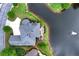 Stunning aerial view of a house with manicured lawn adjacent to a beautiful lake with fountain feature at 9325 Saint Georgen Cmn, Duluth, GA 30097