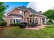 Brick home with a brick patio with an outdoor dining set and lush green lawn at 9325 Saint Georgen Cmn, Duluth, GA 30097