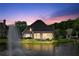 Dusk view of brick home with lights on and a fountain on the waterway at 9325 Saint Georgen Cmn, Duluth, GA 30097