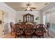 Formal dining room with a large table, ornate china cabinet, plantation shutters, and decorative ceiling fan at 9325 Saint Georgen Cmn, Duluth, GA 30097