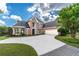 Stately brick home with a circular driveway, lush lawn, mature landscaping, and a three-car garage at 9325 Saint Georgen Cmn, Duluth, GA 30097