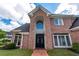 Elegant brick home featuring a striking arched entryway with decorative double doors and manicured landscaping at 9325 Saint Georgen Cmn, Duluth, GA 30097