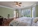 Open main bedroom featuring a king bed, hardwood floors, light green walls, and bay windows at 9325 Saint Georgen Cmn, Duluth, GA 30097