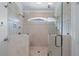 Shower featuring tile surround, glass enclosure, dual shower heads and arched window at 9325 Saint Georgen Cmn, Duluth, GA 30097