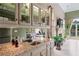 Wet bar with granite counters, wine storage, sink, and glassware cabinets by window at 9325 Saint Georgen Cmn, Duluth, GA 30097