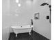 Elegant bathroom featuring a clawfoot tub, black fixtures, and stylish black and white tile work at 1774 Vesta Ave, Atlanta, GA 30337