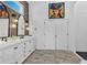 Bright bathroom featuring double sinks, modern fixtures, stylish wallpaper, and white herringbone tiles at 1774 Vesta Ave, Atlanta, GA 30337