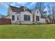 Beautifully landscaped home featuring a white brick facade, dark trim and a well-manicured lawn at 1774 Vesta Ave, Atlanta, GA 30337