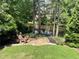 Scenic backyard view featuring a stone patio, outdoor seating, and a serene pond, surrounded by lush greenery at 2743 Long Grove Dr, Marietta, GA 30062