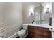 Chic bathroom featuring a designer wallpaper, a dark wooden vanity, and elegant lighting fixtures at 2743 Long Grove Dr, Marietta, GA 30062