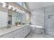 Modern bathroom featuring double sinks, marble accents, a soaking tub, and a glass-enclosed shower at 4648 Glenshire Pl, Atlanta, GA 30338