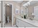 Bright bathroom features double sinks, white cabinetry, large mirror, and stylish lighting fixtures at 4648 Glenshire Pl, Atlanta, GA 30338