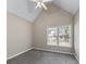 Charming bedroom featuring vaulted ceilings, neutral walls, soft carpet, and a bright window view at 4648 Glenshire Pl, Atlanta, GA 30338