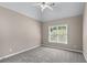 This cozy bedroom features neutral walls, plush carpet, a ceiling fan, and a bright window view at 4648 Glenshire Pl, Atlanta, GA 30338