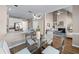 Open-concept dining area featuring a glass table, modern lighting, and seamless transition to the kitchen and living room at 4648 Glenshire Pl, Atlanta, GA 30338