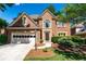 Charming two-story brick home featuring an attached garage and manicured landscaping at 4648 Glenshire Pl, Atlanta, GA 30338