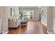 Bright living room with hardwood floors, a comfortable sofa, an ottoman and large windows overlooking the landscaped yard at 4648 Glenshire Pl, Atlanta, GA 30338