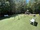 Community playground featuring swings and play equipment on an artificial turf surface with benches nearby at 4648 Glenshire Pl, Atlanta, GA 30338