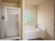 Well-lit bathroom boasts a glass-enclosed shower and a luxurious bathtub with jets at 856 Donington Cir, Lawrenceville, GA 30045