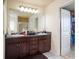 Bathroom featuring a double vanity with dark wood cabinets and access to the closet at 856 Donington Cir, Lawrenceville, GA 30045