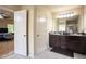 Bathroom featuring a double vanity with dark wood cabinets and access to other rooms at 856 Donington Cir, Lawrenceville, GA 30045