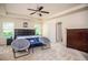 Bright bedroom with a tray ceiling, carpet floors, ceiling fan, and two chairs, perfect for relaxing at 856 Donington Cir, Lawrenceville, GA 30045