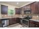 Kitchen with stainless steel appliances, granite countertops, and dark wood cabinetry at 856 Donington Cir, Lawrenceville, GA 30045