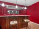 Basement bar with red walls and two barstools at 361 Brackin Trce, Grayson, GA 30017