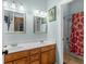 Bright bathroom featuring a double sink vanity, mirrors, and a shower/tub combo at 361 Brackin Trce, Grayson, GA 30017
