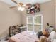 Bright bedroom with a ceiling fan, large window, desk, and pink bedding at 361 Brackin Trce, Grayson, GA 30017