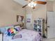 Cozy bedroom with a ceiling fan, white doors, storage shelves, and pink bedding at 361 Brackin Trce, Grayson, GA 30017
