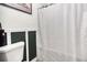 Updated bathroom with white wainscoting and a textured shower curtain at 428 Cornish Mountain Rd, Oxford, GA 30054