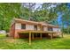 Ranch-style home featuring a red roof, brick foundation, and a wooden deck overlooking the backyard at 428 Cornish Mountain Rd, Oxford, GA 30054