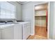 Laundry room with modern washer and dryer and adjacent storage space at 428 Cornish Mountain Rd, Oxford, GA 30054