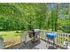 Relaxing back deck area featuring a grill and scenic views of the mature, wooded yard at 115 S Meadowcliff Cir, Carrollton, GA 30116