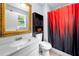 Bathroom with a vanity, mirror, toilet and a shower with a patterned red and black shower curtain at 115 S Meadowcliff Cir, Carrollton, GA 30116