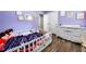 Bright bedroom with wood floors, decorated with wall art, crib and chest of drawers at 115 S Meadowcliff Cir, Carrollton, GA 30116