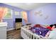 Bright bedroom with wood floors, decorated with wall art, crib, and dresser at 115 S Meadowcliff Cir, Carrollton, GA 30116