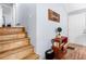 A well-lit entryway with hardwood floors, small console table, staircase and a door leading to the rest of the house at 115 S Meadowcliff Cir, Carrollton, GA 30116