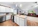 Spacious open-concept kitchen and living room with vaulted ceiling, hardwood floors, island and access to the staircase at 115 S Meadowcliff Cir, Carrollton, GA 30116