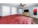 Spacious main bedroom with hardwood floors, a ceiling fan, bathroom access, two closets and a dresser with TV at 115 S Meadowcliff Cir, Carrollton, GA 30116